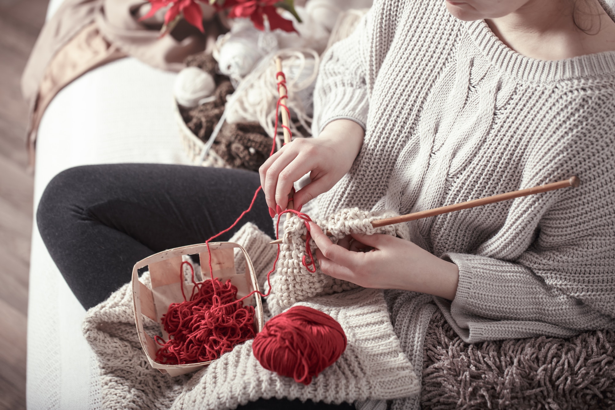 woman knits knitting needles on the couch